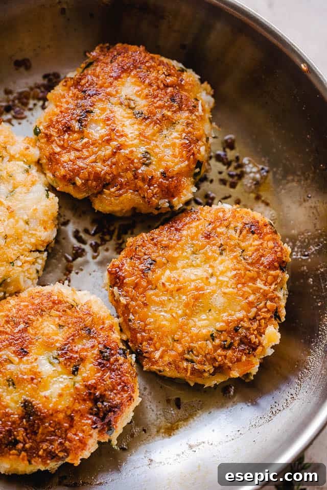 Crispy Coconut Shrimp Patties 5 Coconut shrimp cakes cooking in a skillet on the stove