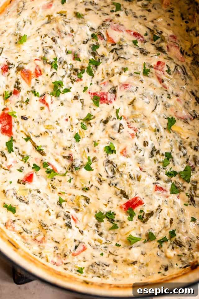 Upclose overhead shot of a perfectly cooked and bubbly spinach artichoke dip, ready to be served from the slow cooker.