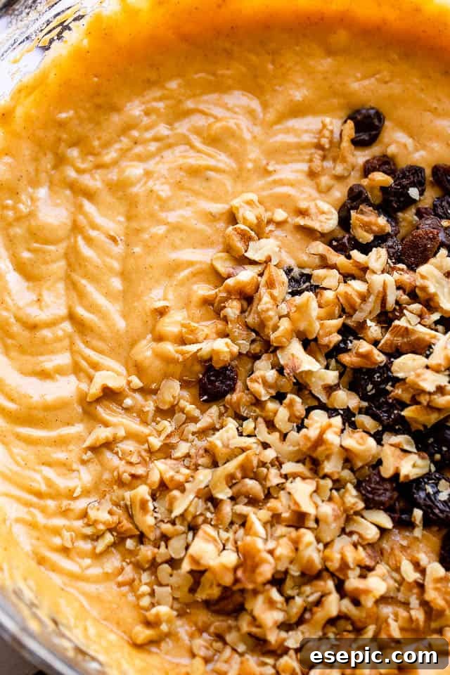A mixing bowl filled with a rich, orange pumpkin batter, hinting at the warm, spiced flavors within this homemade pumpkin bread recipe.