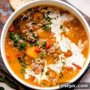 overhead shot of butternut squash and sausage soup in a white soup bowl