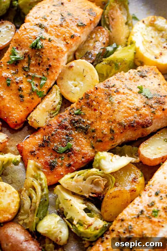 Old Bay Salmon is an easy roasted salmon recipe made with classic Old Bay seasoning! It's a flavorful and simple way to make the best flaky salmon dinner! overhead shot of roasted salmon fillets with brussel sprouts and yellow squash