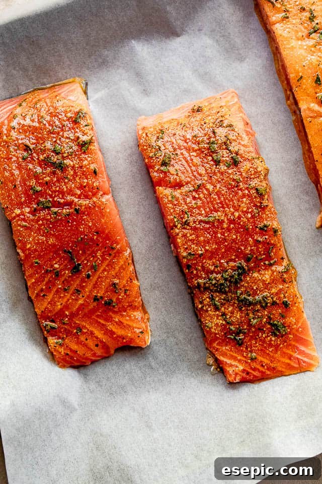 Old Bay Salmon is an easy roasted salmon recipe made with classic Old Bay seasoning! It's a flavorful and simple way to make the best flaky salmon dinner! overhead shot of seasoned raw salmon fillets