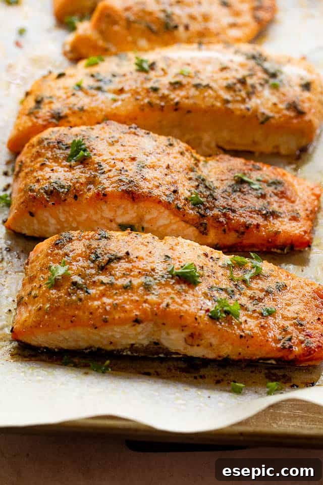 Old Bay Salmon is an easy roasted salmon recipe made with classic Old Bay seasoning! It's a flavorful and simple way to make the best flaky salmon dinner! side shot of cooked salmon fillets seasoned with old bay seasoning