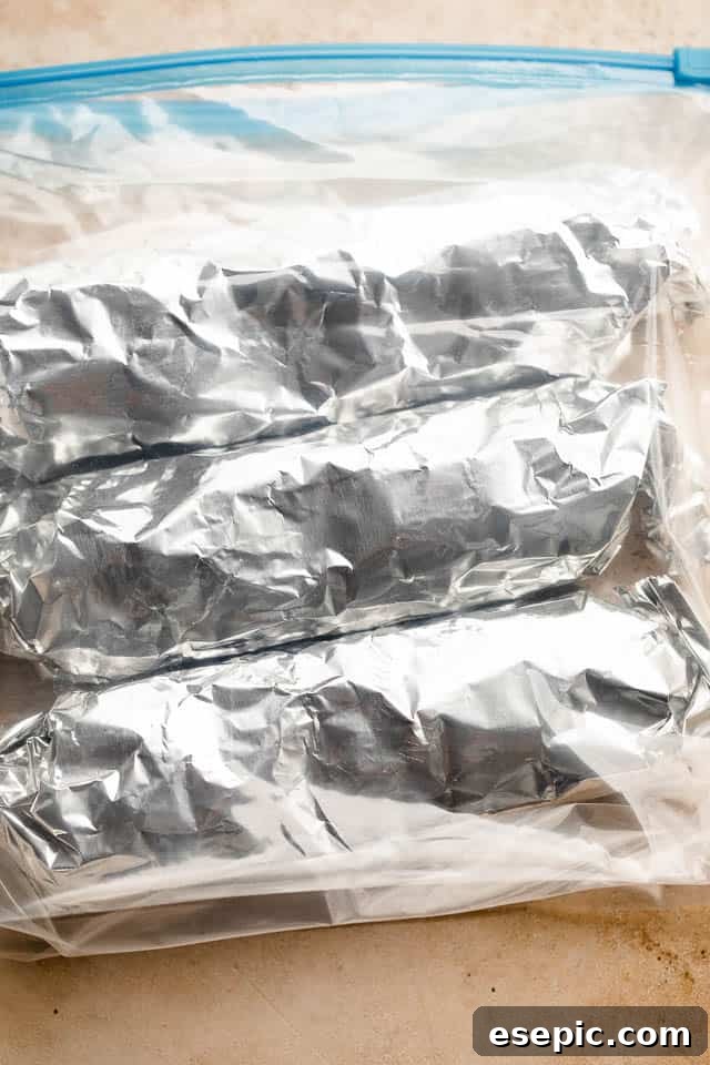 individual burritos wrapped in foil and placed inside ziploc bags.