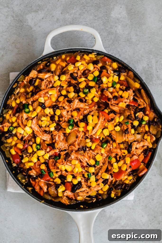 A Large Skillet Filled With A Hearty Chicken Enchilada Casserole