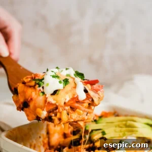 A Serving of Chicken Enchilada Casserole on a Large Wooden Scoop
