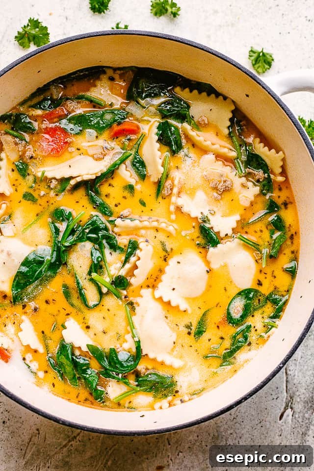 Overhead image of a large pot brimming with creamy ravioli soup, showcasing tender ravioli, vibrant spinach, and savory ground turkey in a rich, inviting broth.
