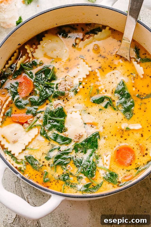 An overhead view of creamy ravioli soup simmering in a pot, highlighting the rich broth, tender ravioli, and fresh ingredients.