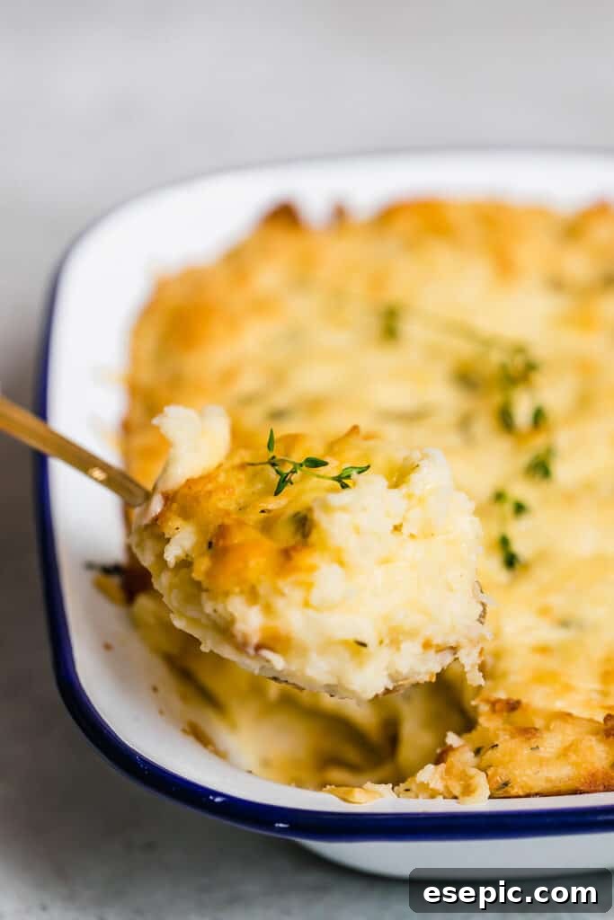 close up side shot of scooping out mashed potatoes from baking dish