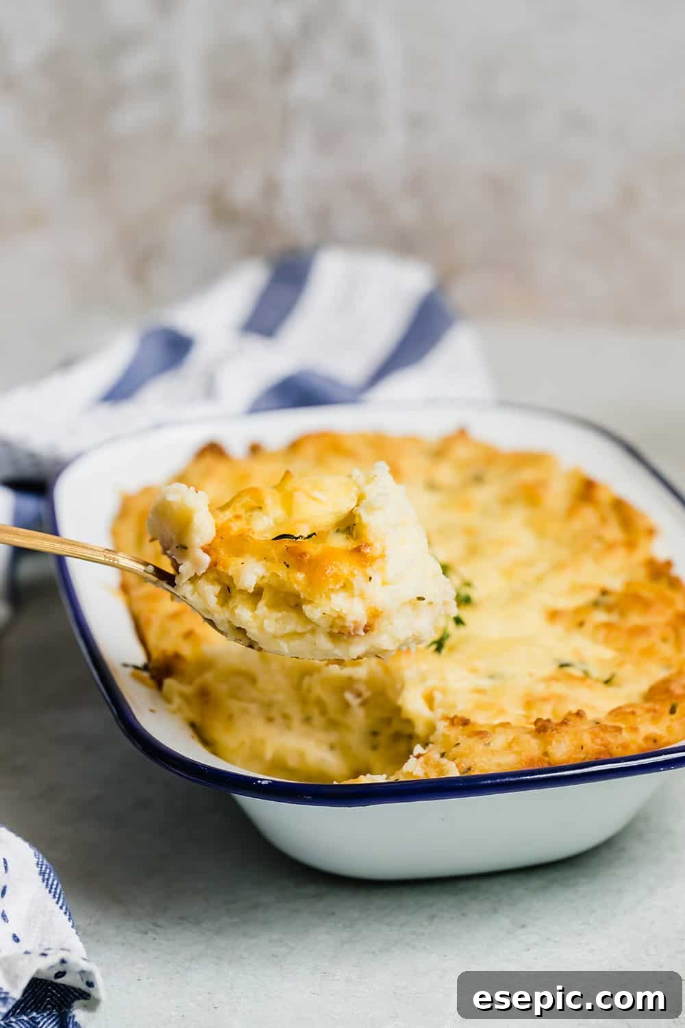 A spoon scooping creamy mashed potatoes out of a dish.