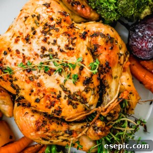 Overhead close-up shot of whole roast chicken served on a platter.