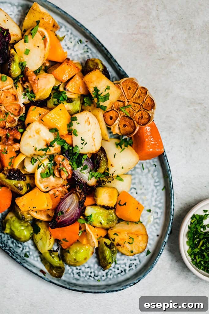 Perfectly golden and tender roasted root vegetables on a vibrant blue serving platter, glistening and ready to eat.