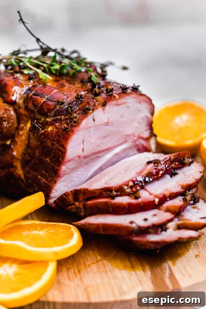 A Glazed Christmas Ham with Four Slices Cut Off, showcasing its diamond scoring and glistening glaze.