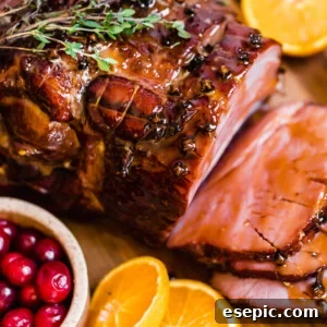 Slices of Christmas Ham on a Circular Wooden Surface with Assorted Fruits