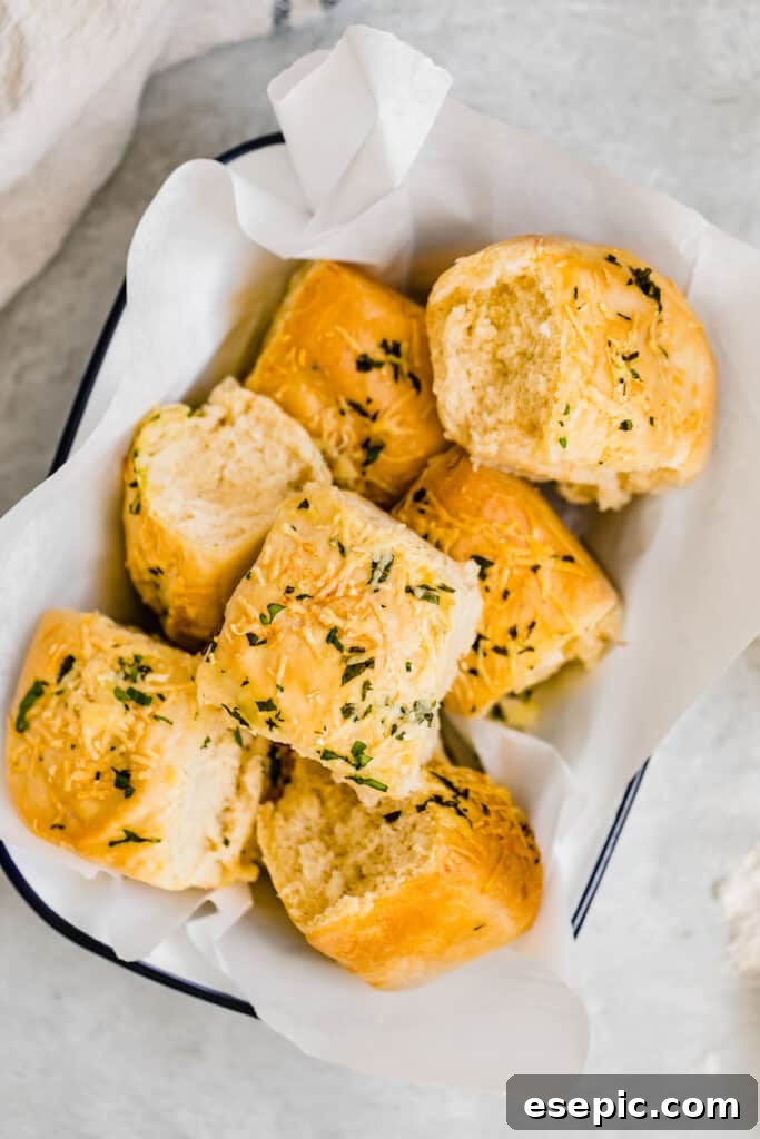 Seven Soft Parmesan Dinner Rolls in a Basket Lined with Tissue Paper