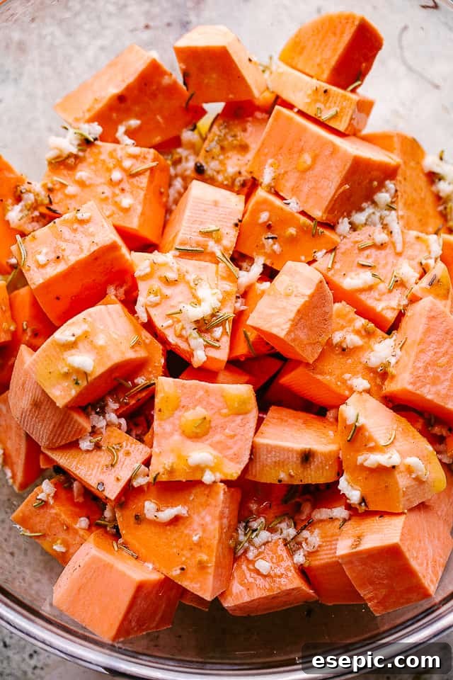 Chopped Sweet Potatoes in a Mixing Bowl Overhead shot of neatly chopped raw sweet potatoes in a large mixing bowl, ready to be coated with the glaze.