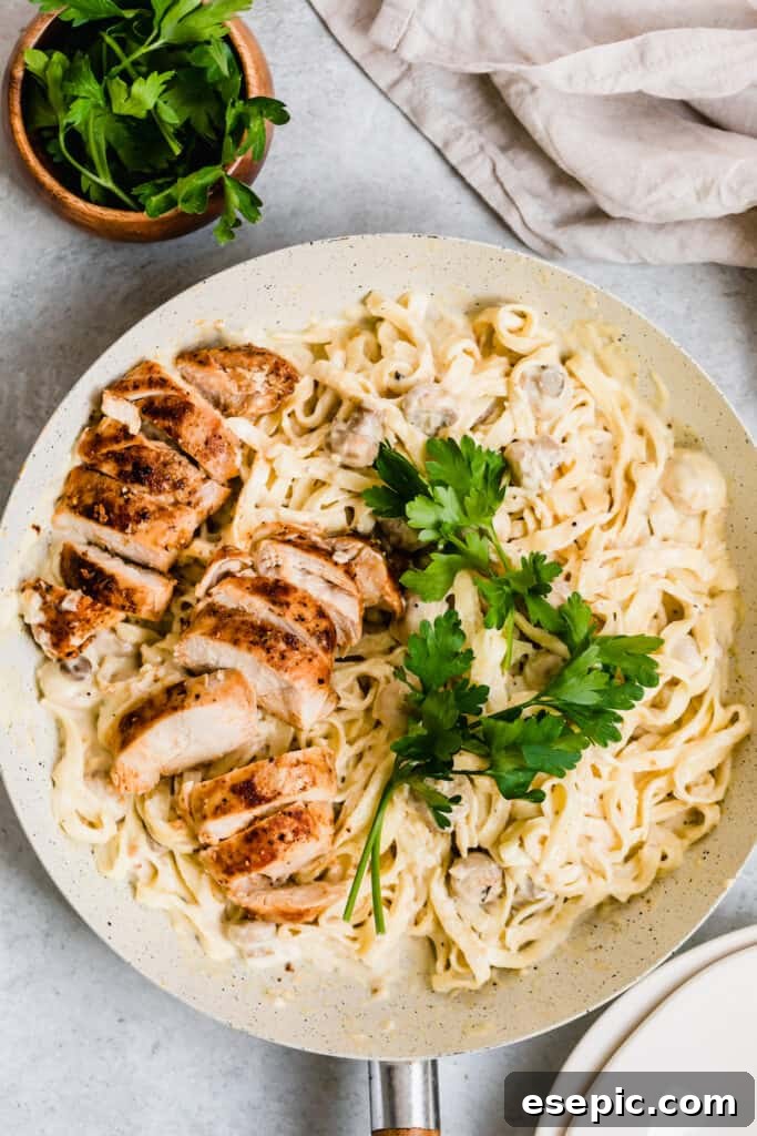 Two Sliced Chicken Breasts Over a Bowl of Creamy Fettuccine Alfredo
