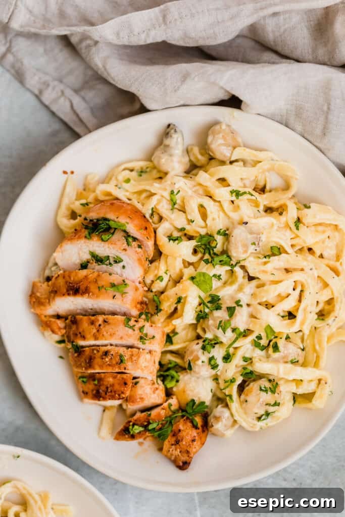 A Bowl of Creamy Fettuccine Alfredo with Mushrooms and Sliced Chicken Breast