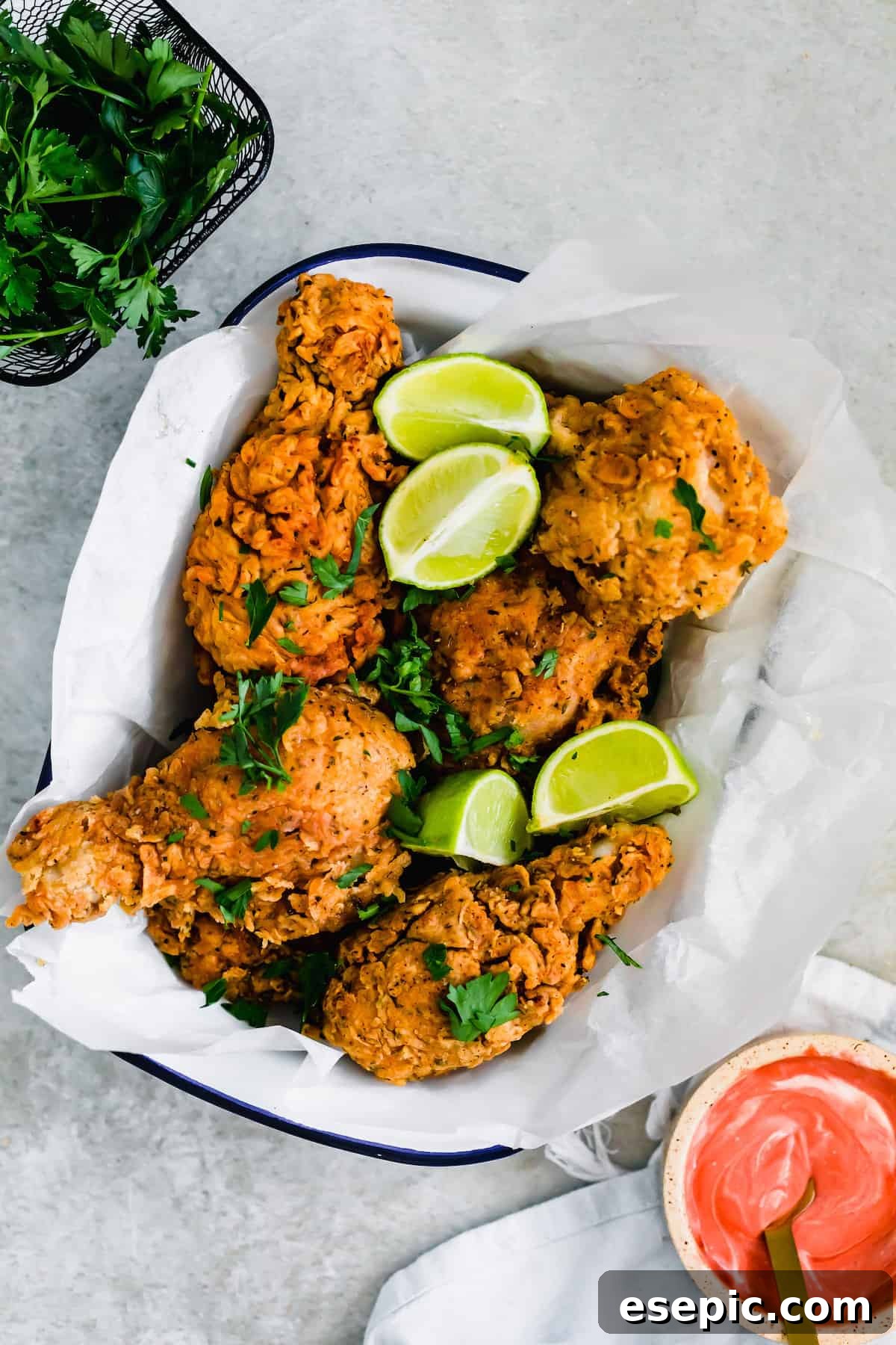 A Bowl of Buttermilk Fried Chicken Next to a Container of Fresh Parsley