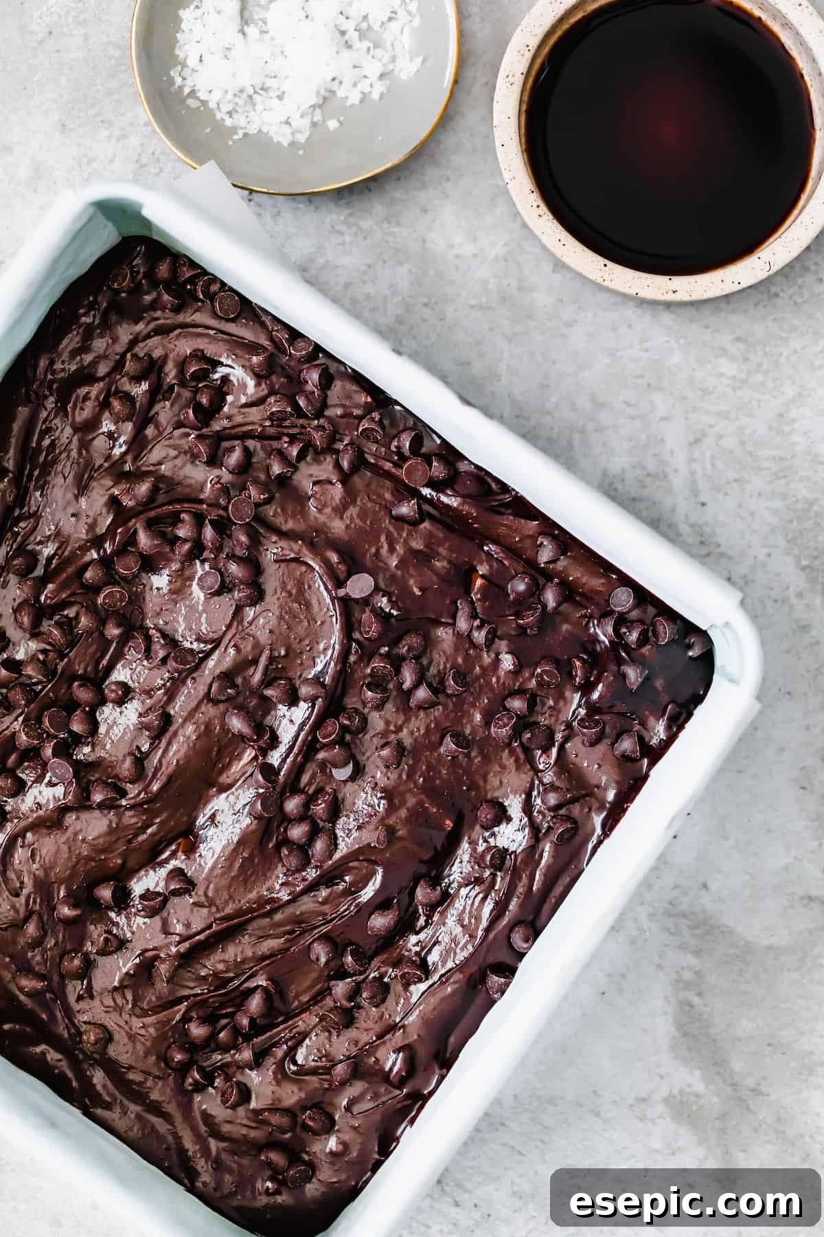 Homemade Brownies in a Pan with Mini Chocolate Chips on Top, glistening and ready for the oven