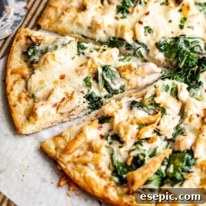 side shot of sliced chicken alfredo pizza