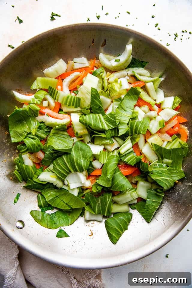 Sticky Honey Balsamic Beef 4 stir frying bok choy, onions, and bell peppers in a skillet