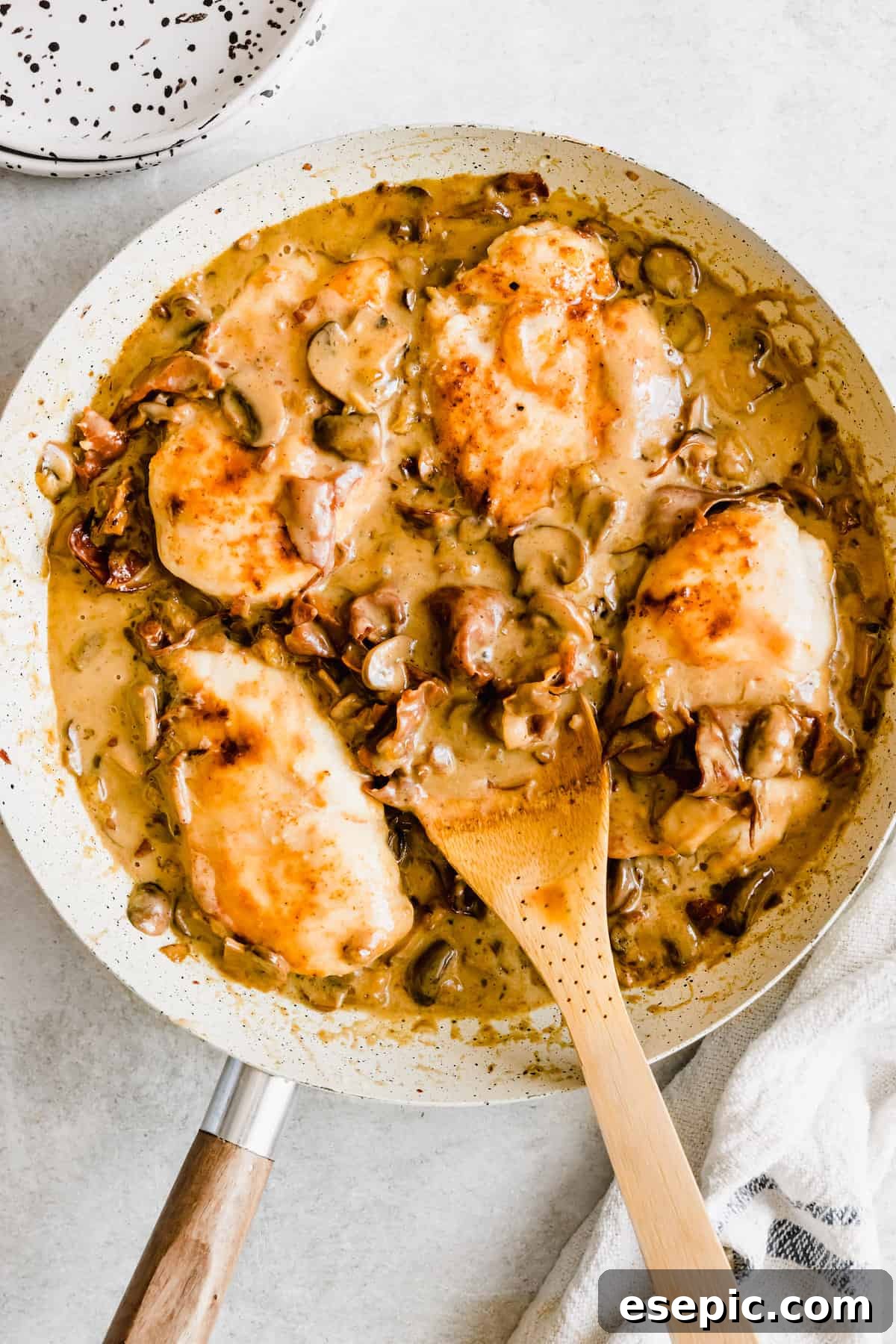 Four pieces of chicken in a mushroom marsala sauce.