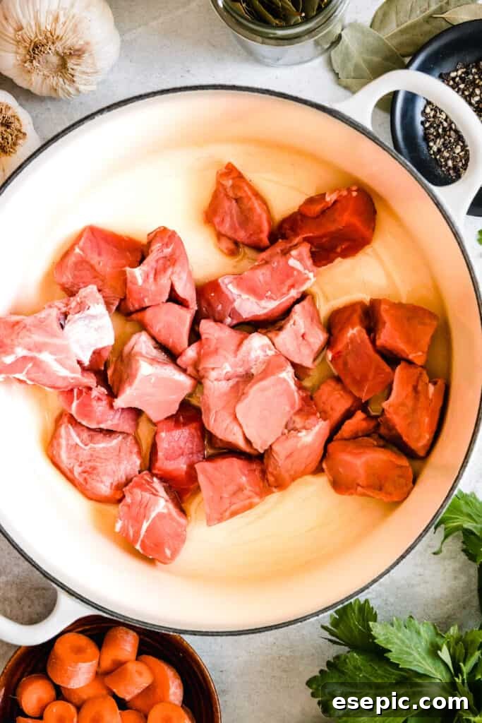 Slow-Simmered Guinness Beef Stew 6 Tender beef chunks, seasoned and ready for searing, arranged neatly in a skillet.