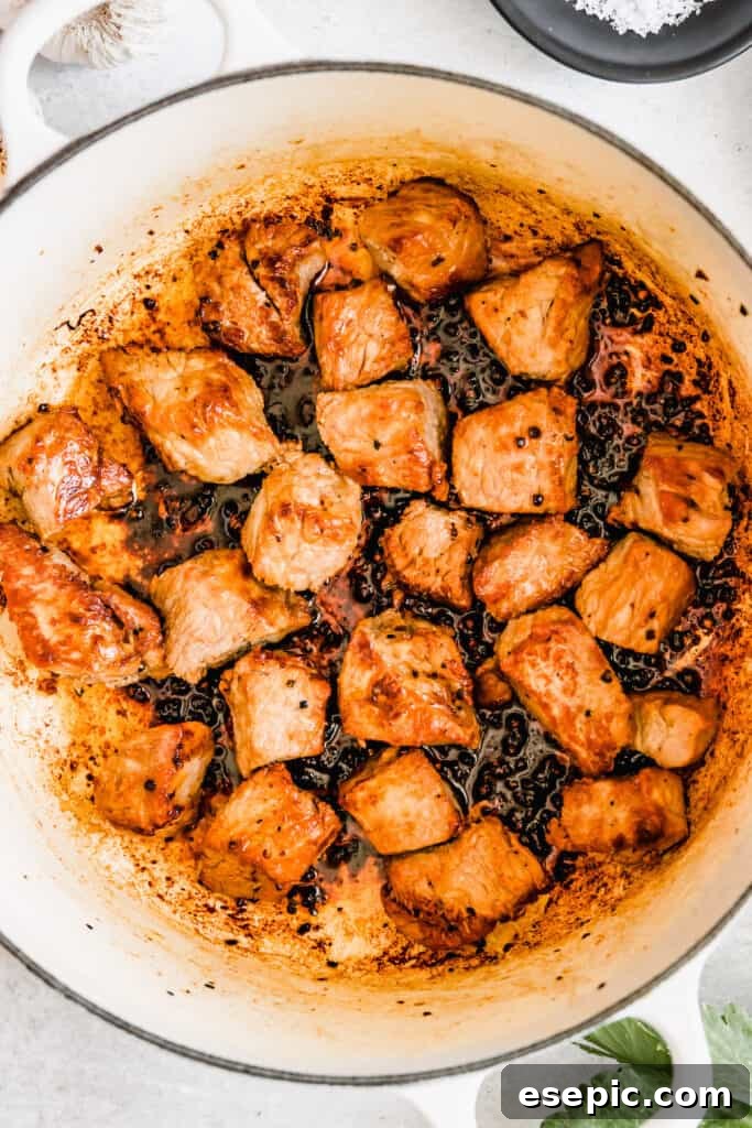 Slow-Simmered Guinness Beef Stew 7 Chunks of beef sizzling and browning beautifully in a heavy-bottomed pot, developing a rich crust for maximum flavor.