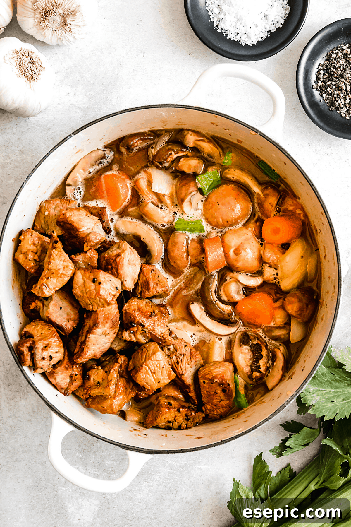 Slow-Simmered Guinness Beef Stew 10 A rich, simmering overhead shot of Guinness beef stew, showcasing tender beef and colorful vegetables in a white Dutch oven, ready to be served.