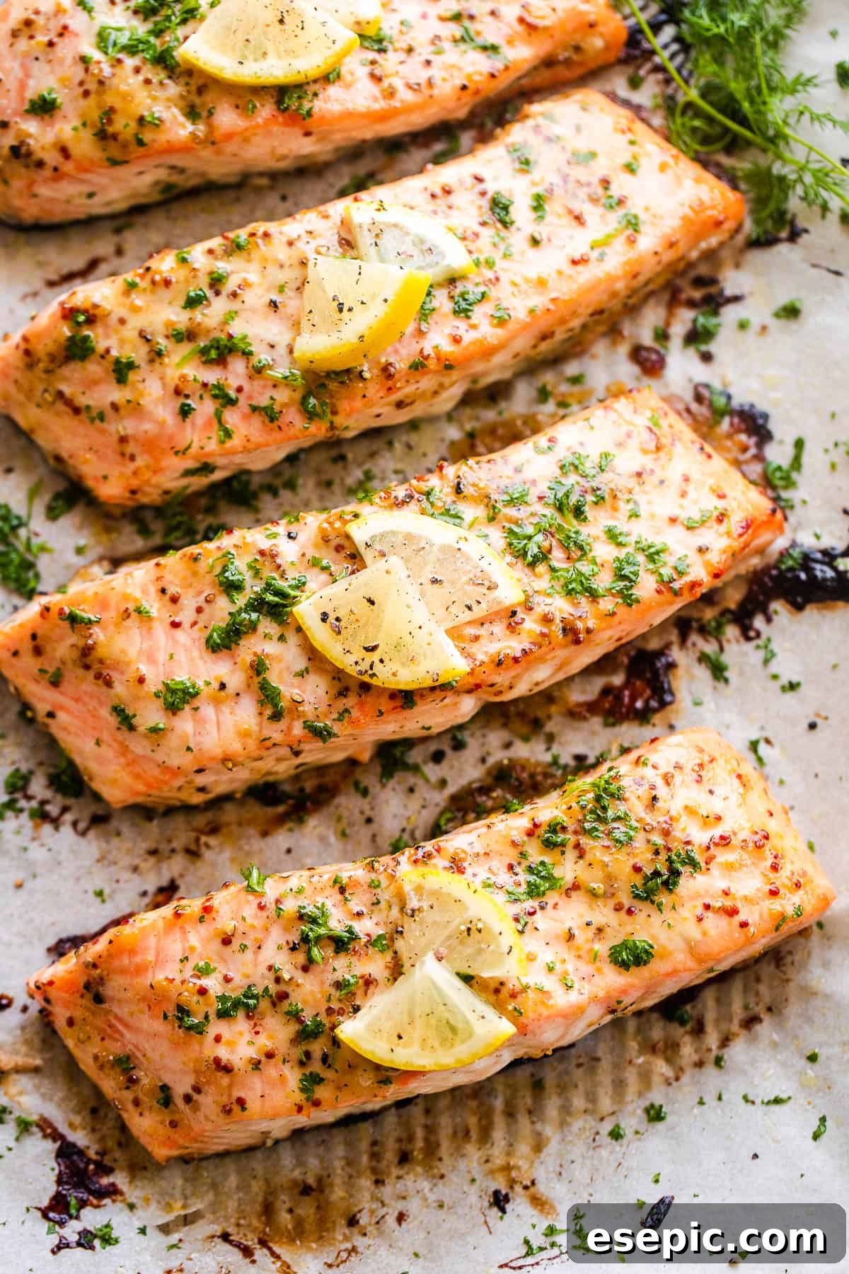 four maple mustard salmon fillets arranged on a baking sheet