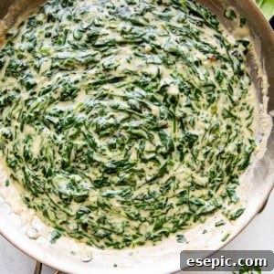 overhead picture of creamed spinach cooking in a large skillet.