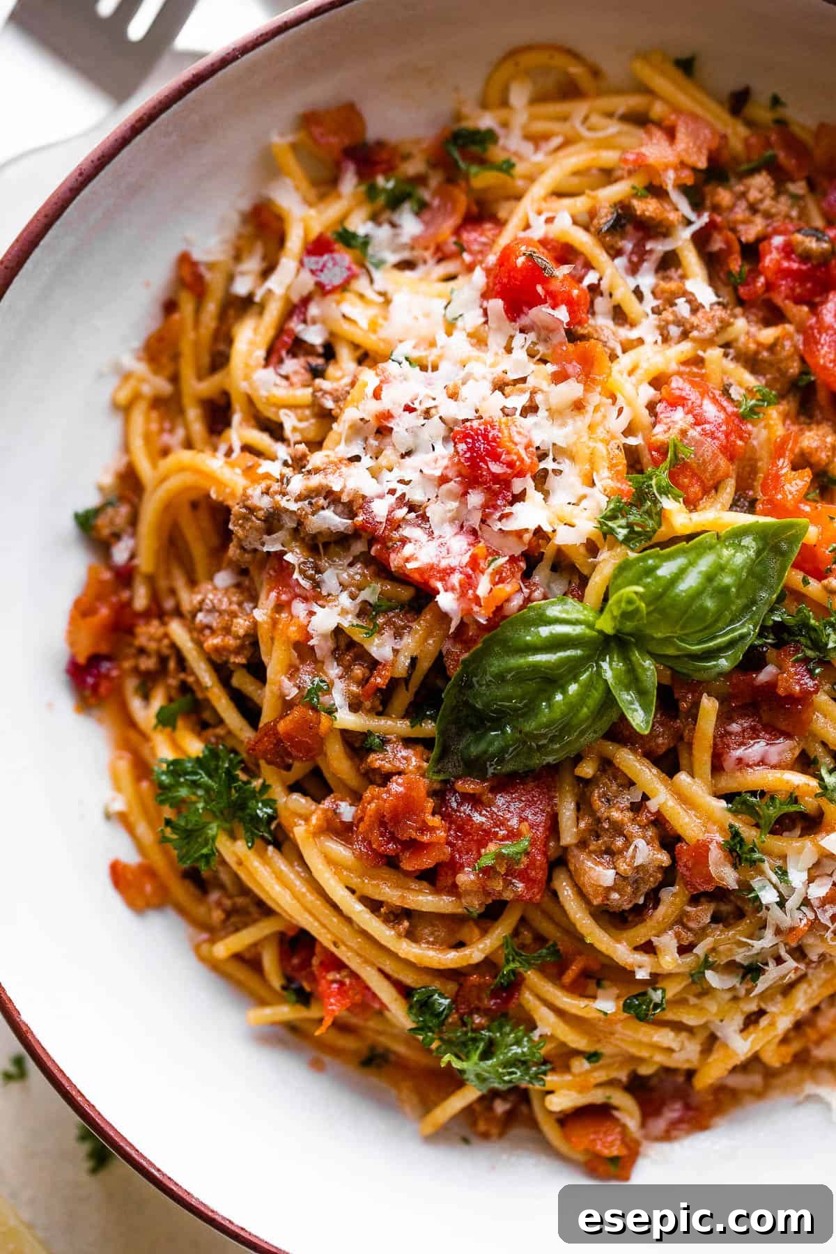 Instant Pot Spaghetti served in a white pasta bowl, garnished with fresh basil and Parmesan cheese.