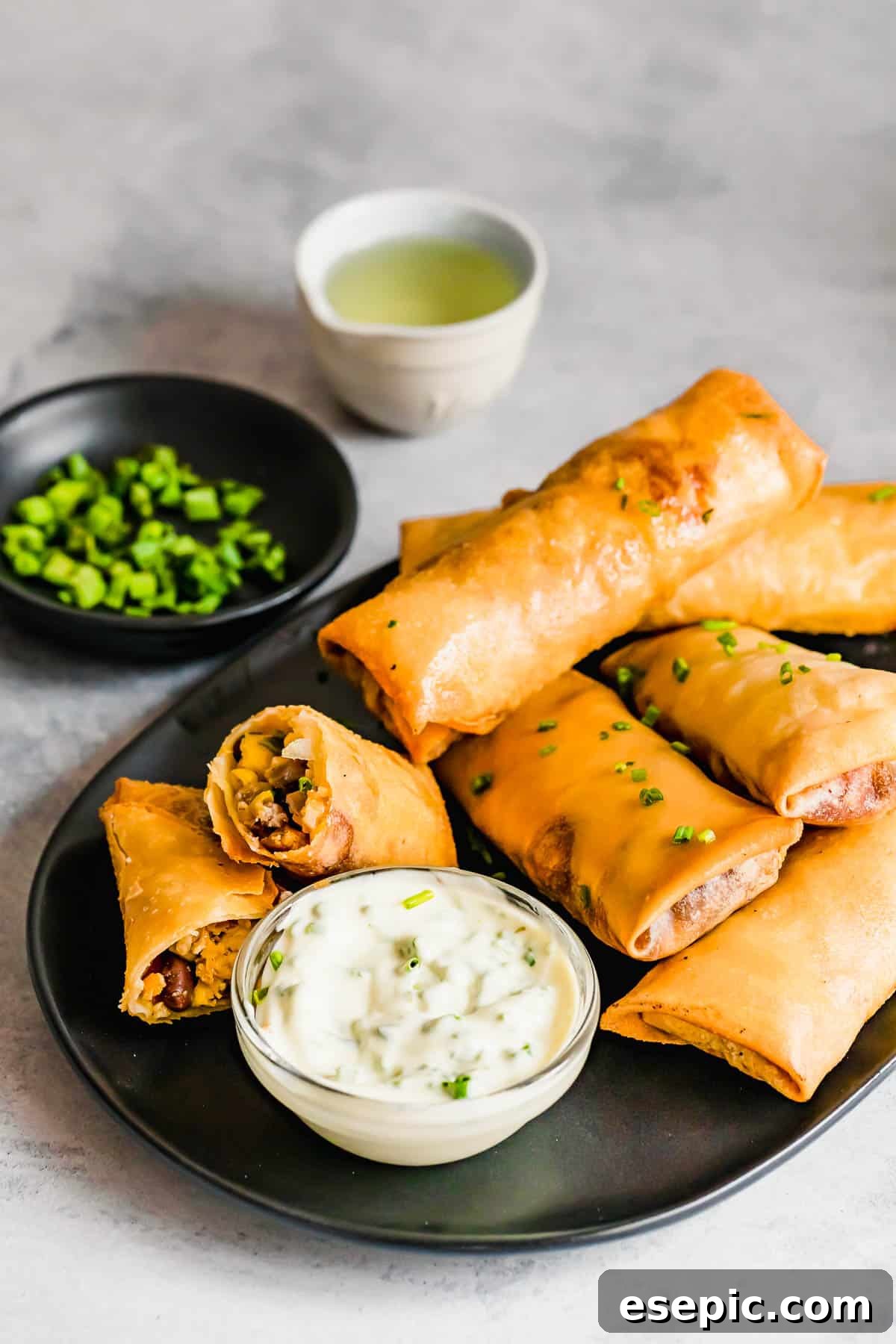 A Plate of Egg Rolls with a Glass Dish of Dipping Sauce