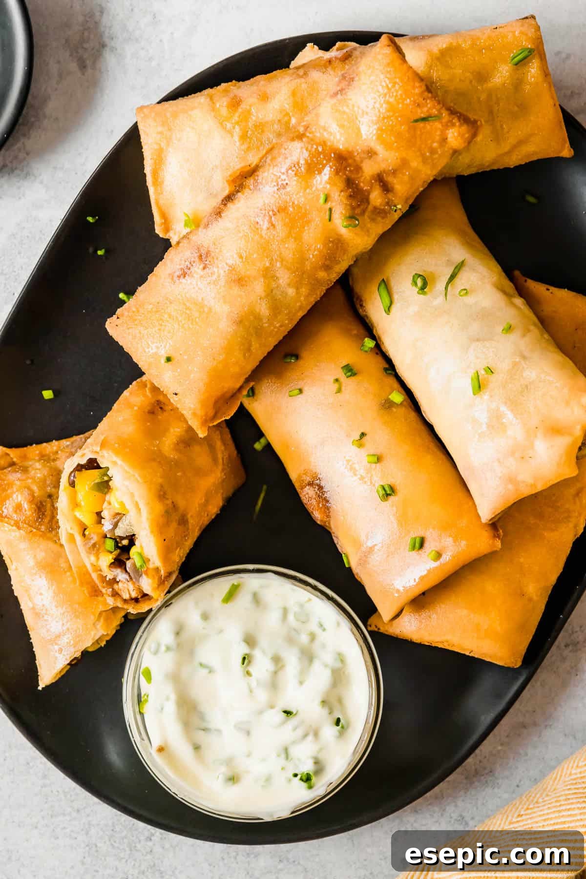 A Plate of Egg Rolls with a Glass Dish of Dipping Sauce