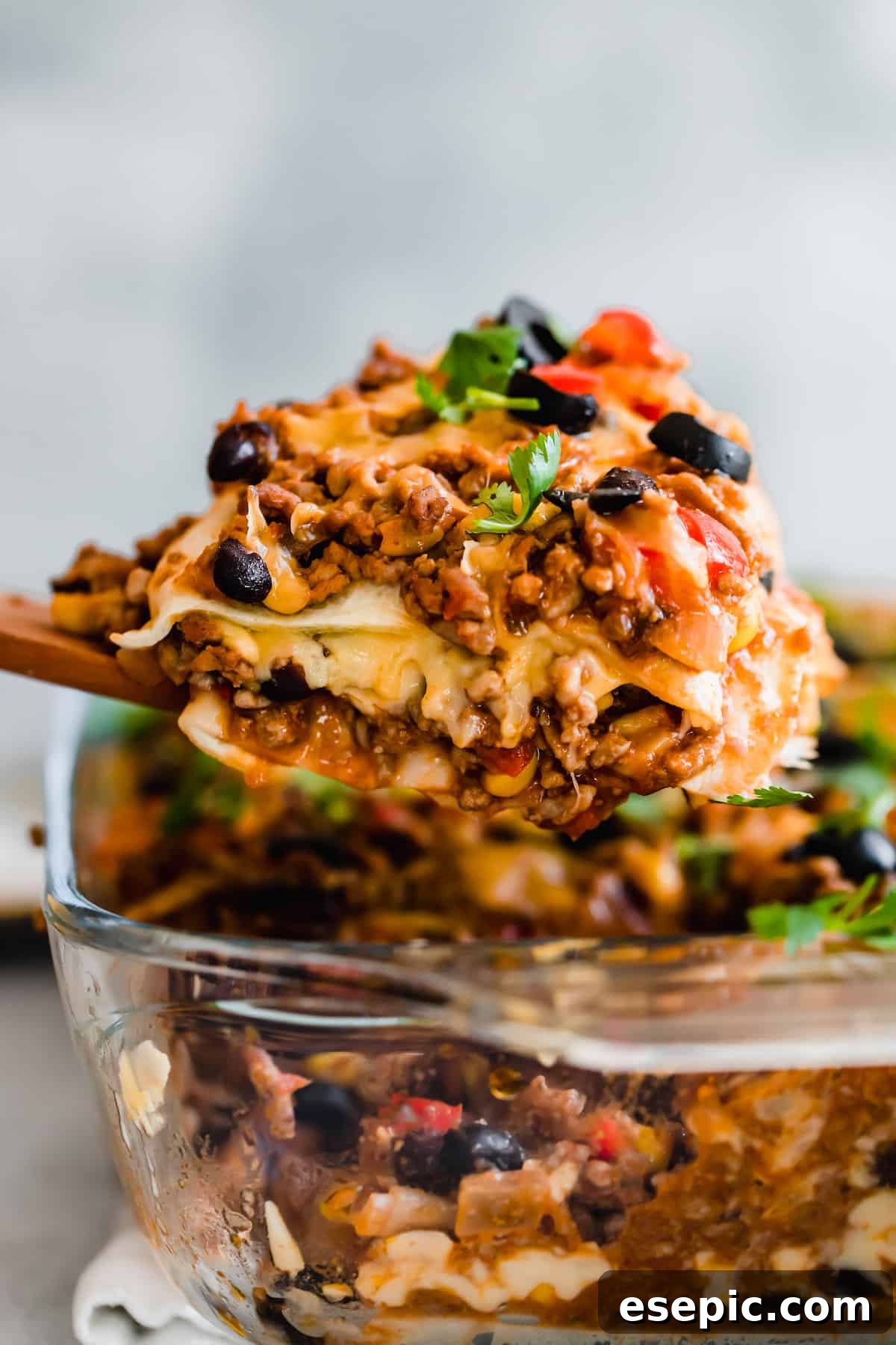 A Scoop of Lasagna Hovering Over the Rest of the Casserole in a Glass Pan