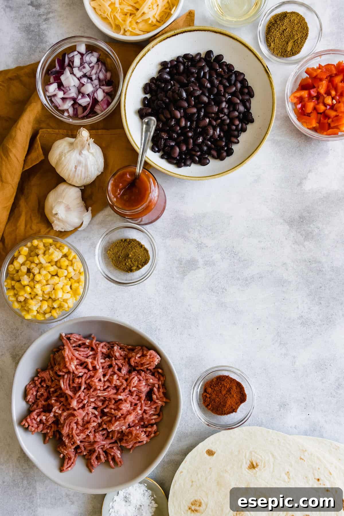 Black Beans, Corn, Diced Onions, Chili Powder and the Remaining Casserole Ingredients on a Countertop