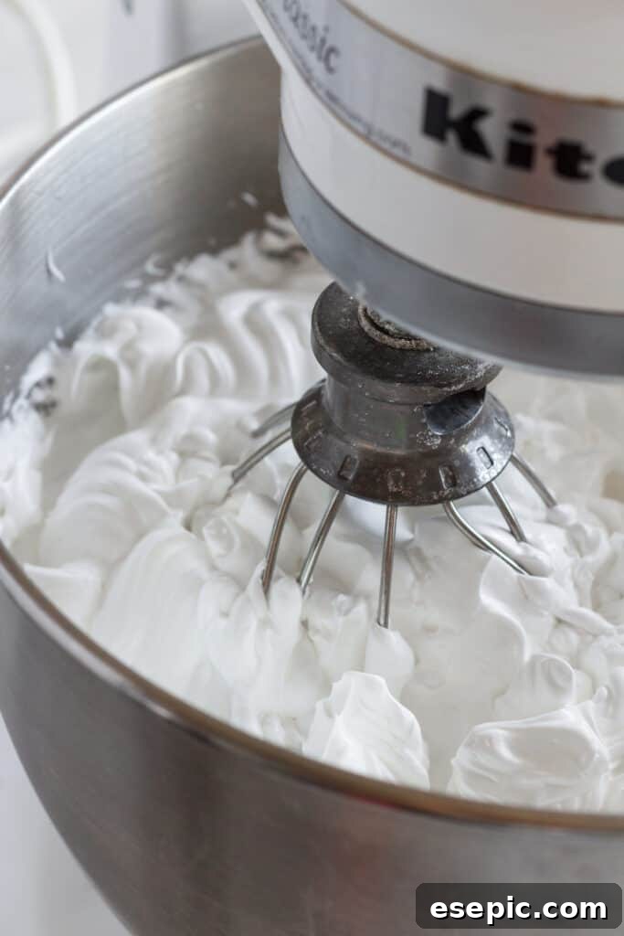Effortless Strawberry Meringue Nests 6 A stand mixer in action, whipping egg whites into soft peaks for the pavlova base.
