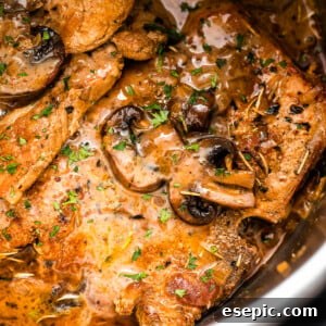 Close-up shot of pork chops in the Instant Pot topped with mushroom gravy sauce