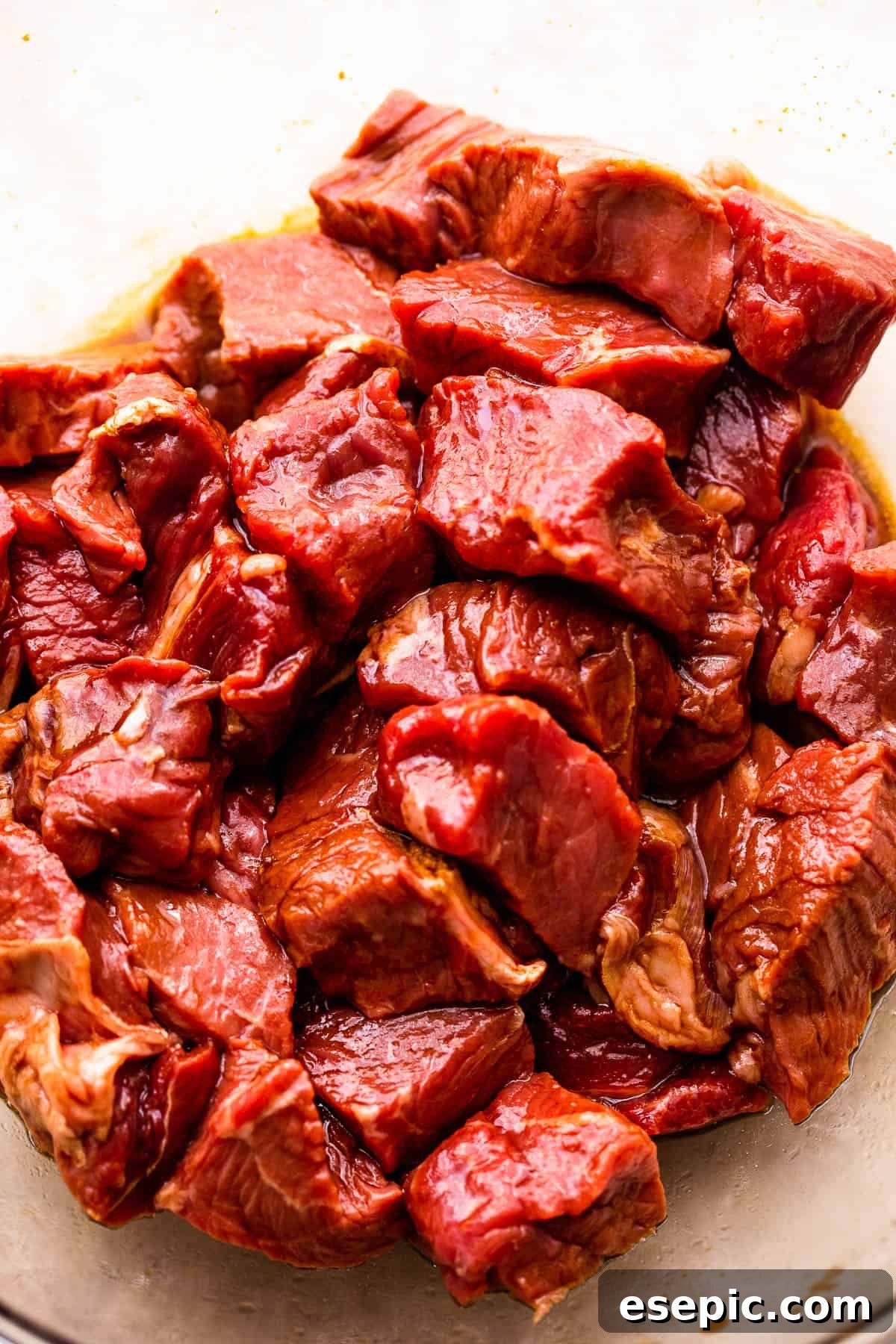Garlicky Steak Bites and Crispy Potatoes 4 marinating steak bites in a glass bowl