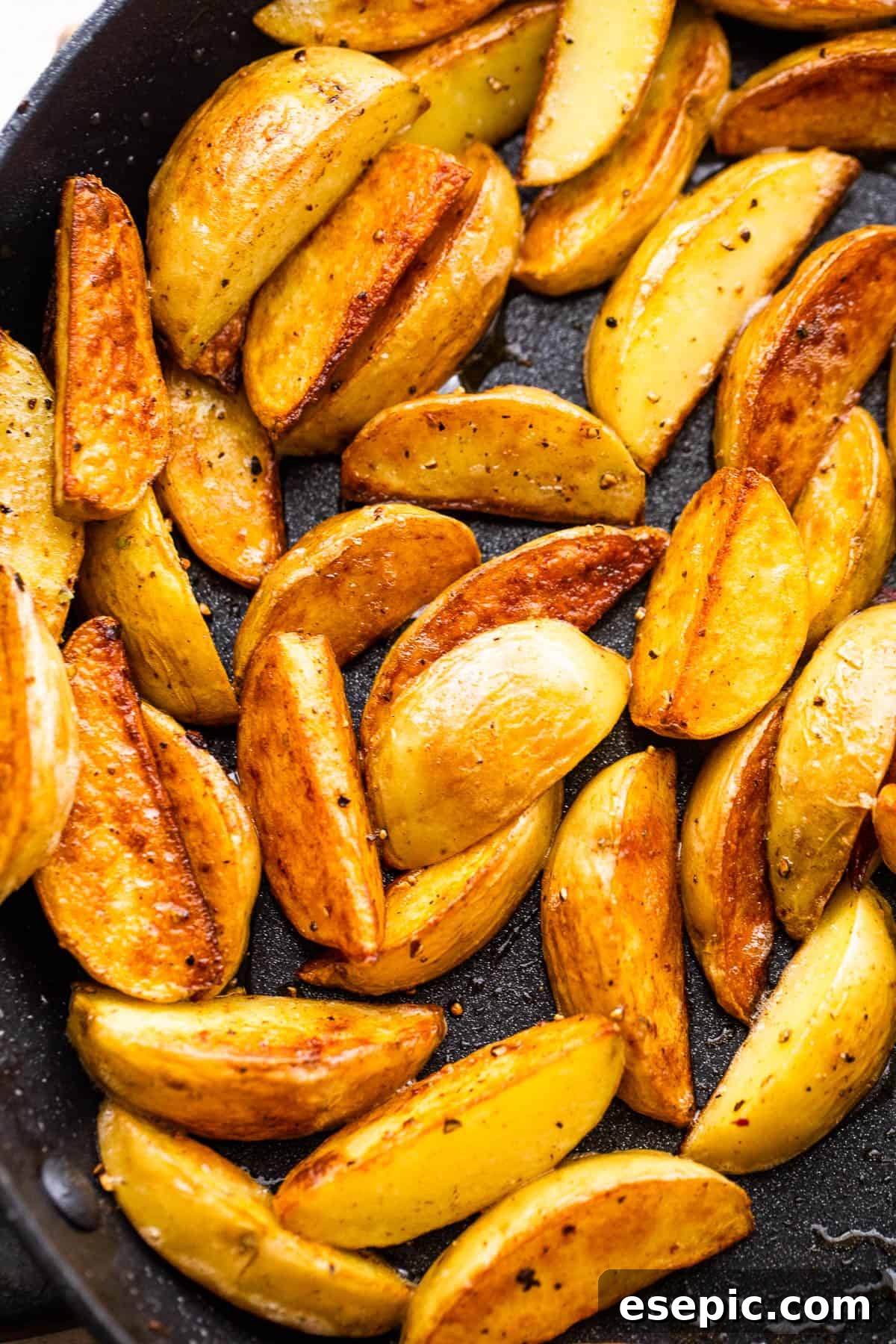 Garlicky Steak Bites and Crispy Potatoes 5 up close shot of quartered baby potatoes in a skillet