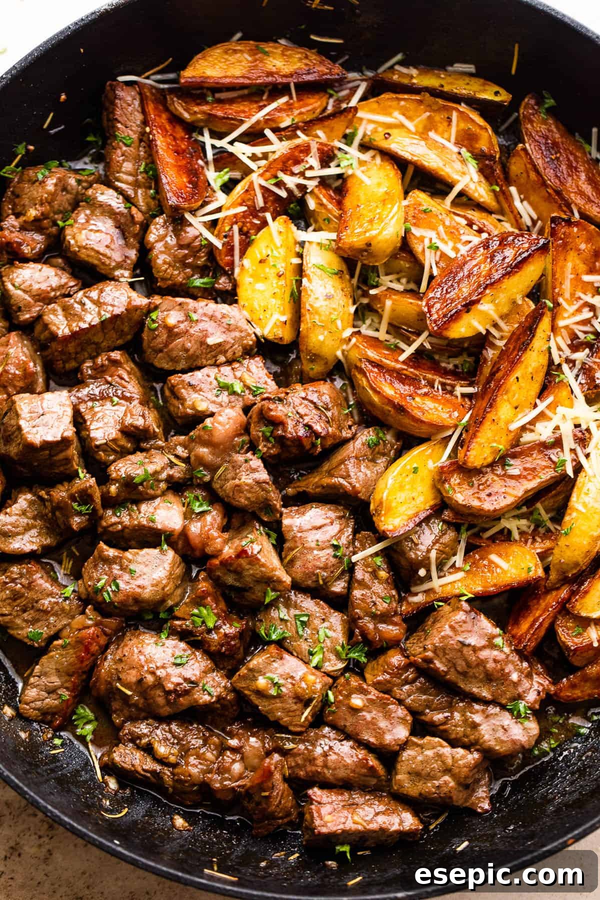 Garlicky Steak Bites and Crispy Potatoes 6 overhead shot of sirloin steak bites and quartered gold potatoes in a skillet