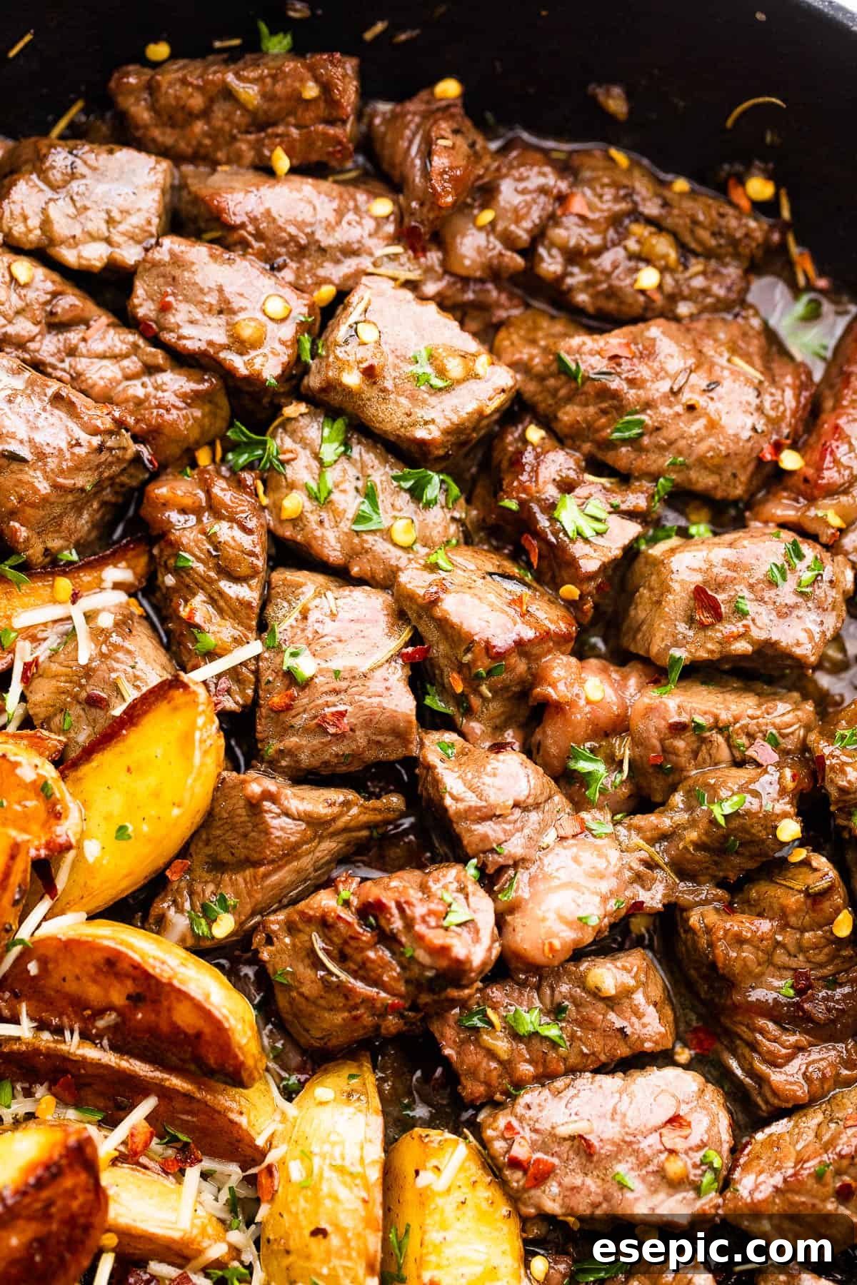 Garlicky Steak Bites and Crispy Potatoes 7 cubed sirloin steak bites cooking in a skillet