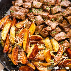 Garlicky Steak Bites and Crispy Potatoes 8 cubed steak and quartered potatoes cooking in a skillet