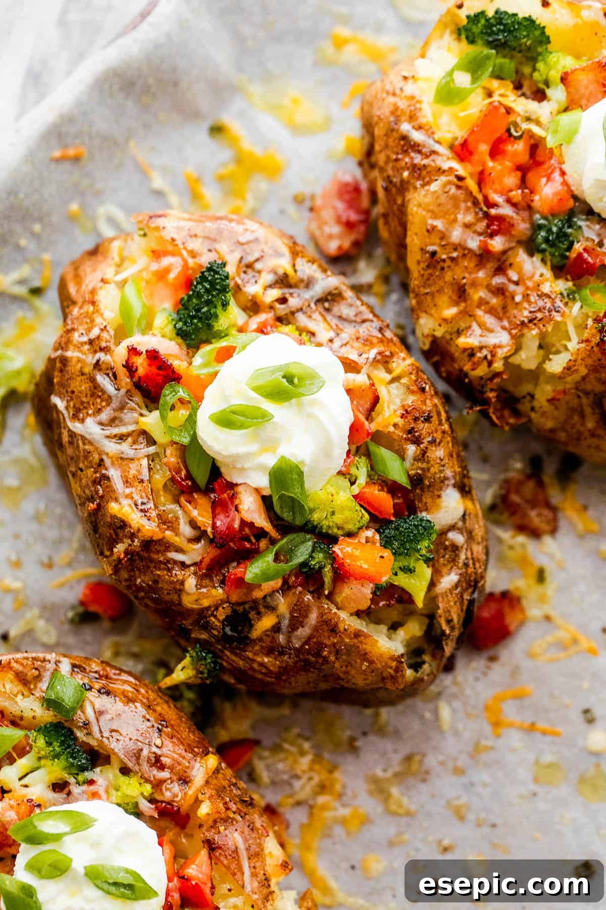 Three Instant Pot Baked Potatoes Beside Bowls of Cheese, Broccoli, Bacon, Chopped Green Onions and Sour Cream