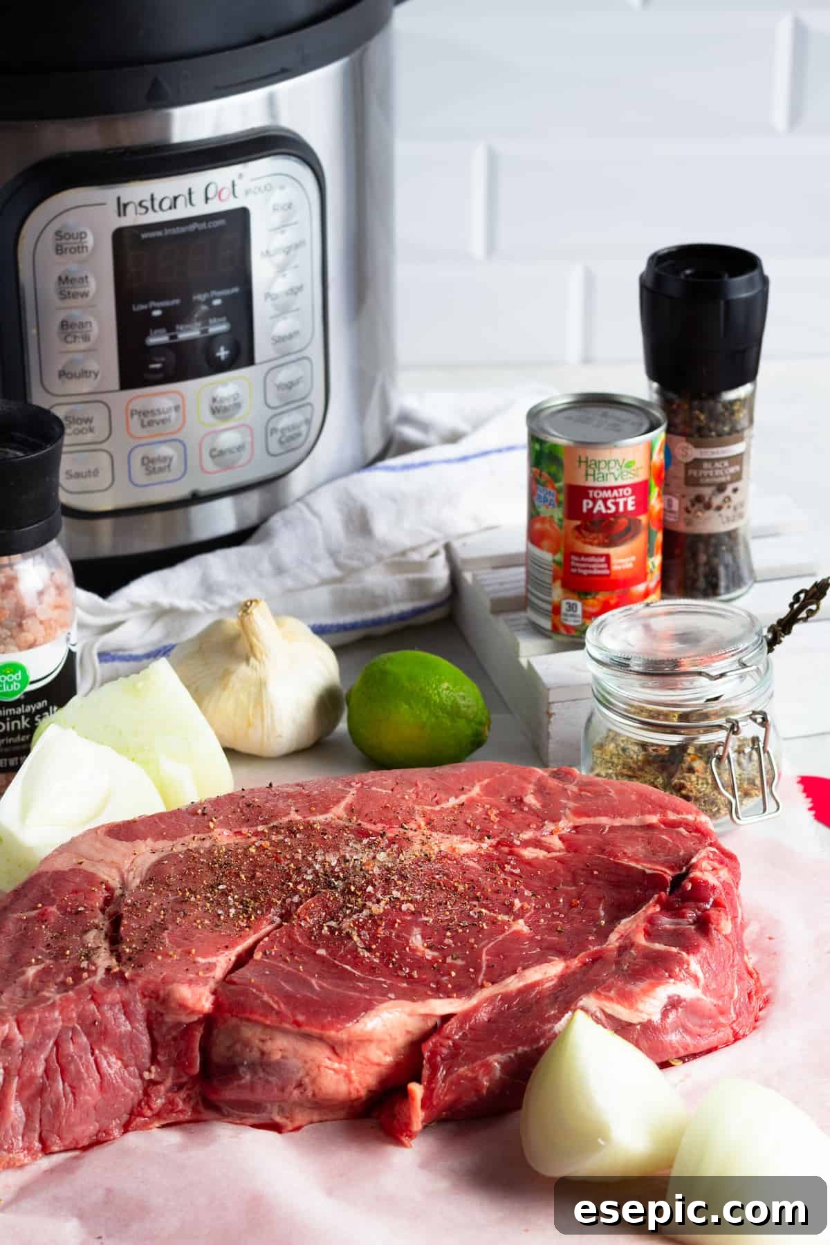 An Instant Pot, Tomato Paste, a Chuck Roast, Onions, a Lime and the Other Beef Barbacoa Ingredients