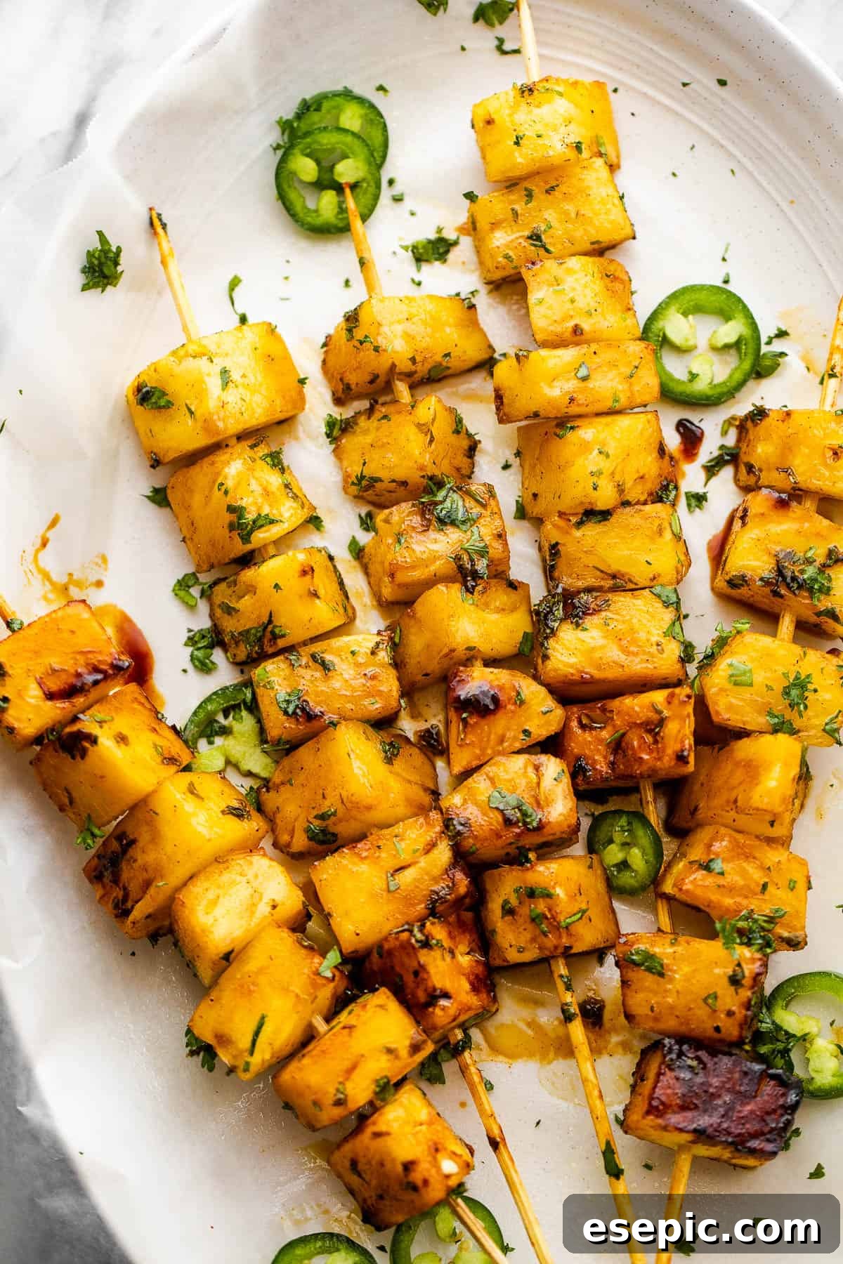 Tequila Kissed Grilled Pineapple 3 Five vibrant tequila grilled pineapple skewers ready to be served.