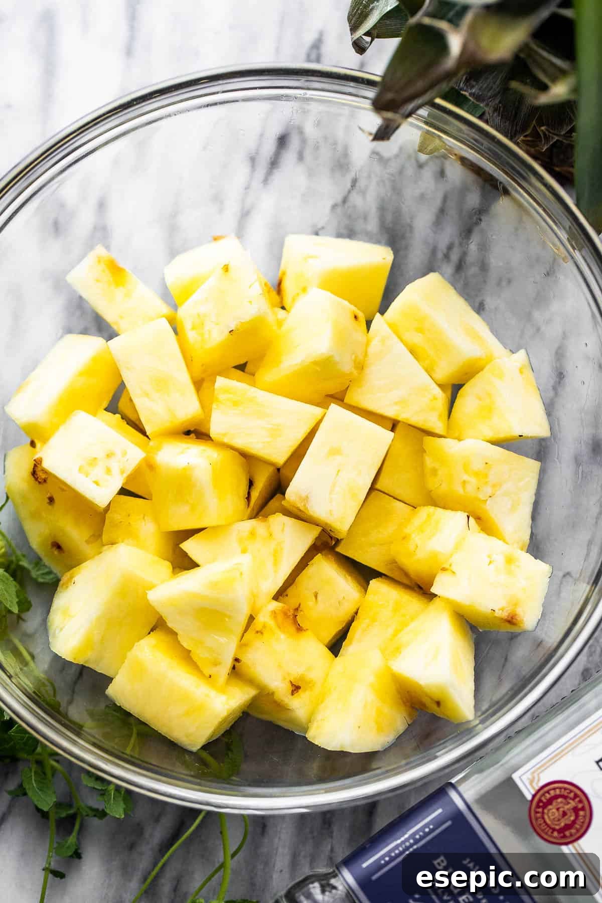 Tequila Kissed Grilled Pineapple 4 Diced fresh pineapple in a clear glass bowl, ready for preparation.