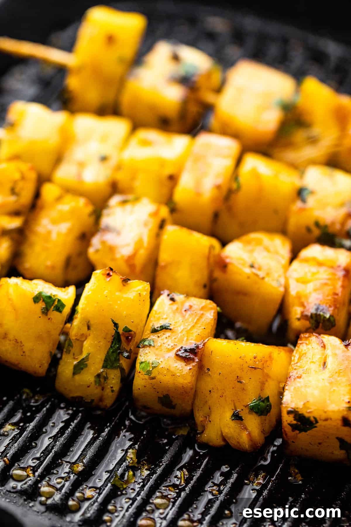 Tequila Kissed Grilled Pineapple 6 Pineapple skewers sizzling on a hot grill, creating a beautiful char.