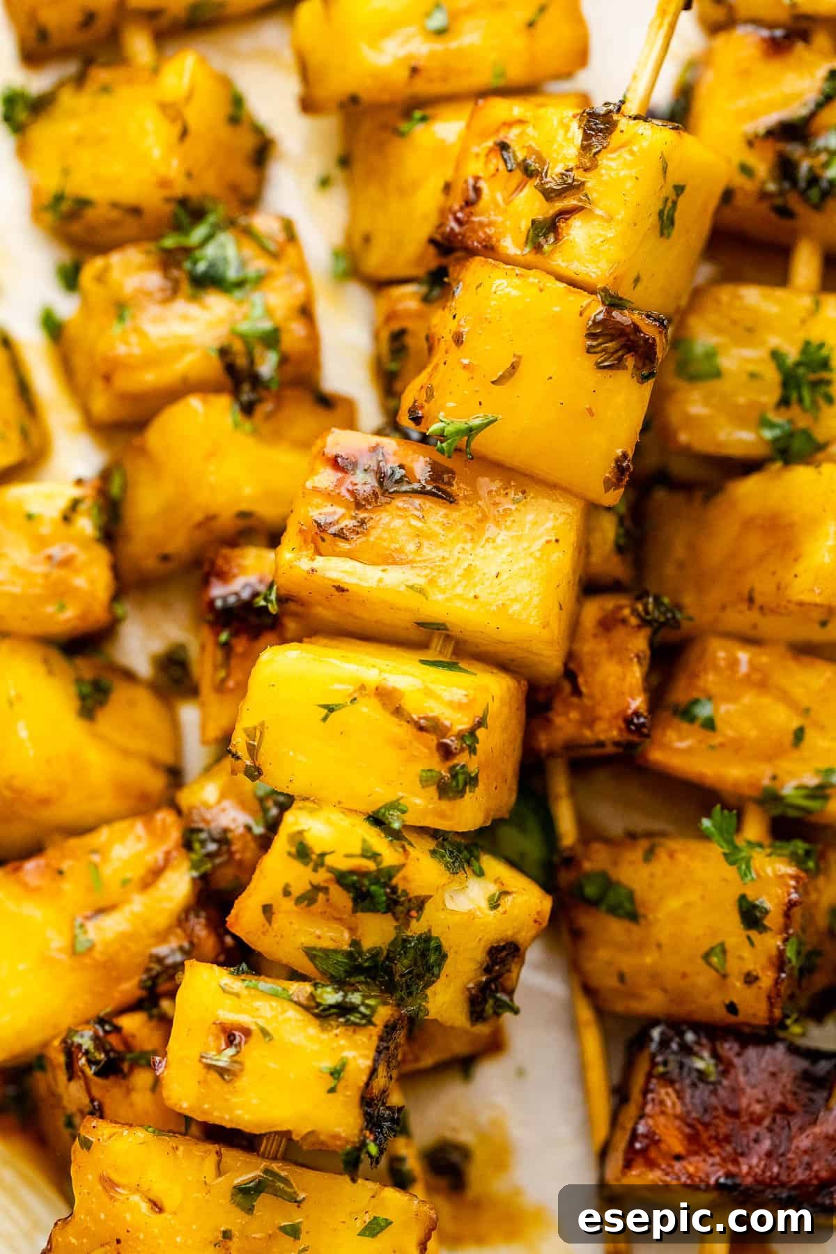 Tequila Kissed Grilled Pineapple 8 Close-up shot of grilled pineapple skewers arranged on a plate, showcasing the char marks and juicy texture.